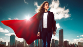 Successful businesswoman wearing a red superhero cape  with a city skyline in the background