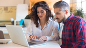 coworkers looking at a laptop discussing a project