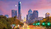 The Austin skyline photographed at dusk as the moon lingers in the horizon.