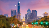 The Austin skyline photographed at dusk as the moon lingers in the horizon.