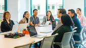 Udemy team members sitting around conference table in discussion