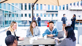 Cisco Meraki team members gather under an umbrella on a rooftop deck