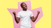 Man standing in front of abstract pink and yellow background, with fists upraised in excitement, ready to take on a new role