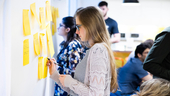 JPMorgan Chase team member writing on post-it notes on a whiteboard
