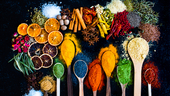 Many multi colored spices and dried fruits on the table