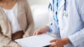 doctor with clipboard talking to patient