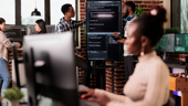 Engineers reviewing code on a monitor in the office