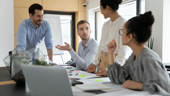 A sales team meets around a table