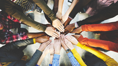 Close up of a diverse group of people stacking their hands together