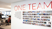 One Team wall with photographs inside AlertMedia office