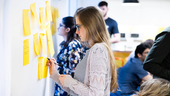 JPMorgan Chase team member writing on post-it notes on a whiteboard