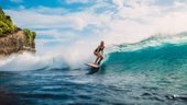 A woman surfs a wave