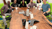 Fetch employees smile at the camera from around a conference table.