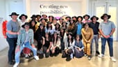 A group photo of the Udemy team wearing matching wide brimmed hats.