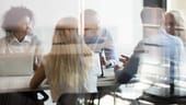stylized image of a board room with people form diverse backgrounds sitting around a table