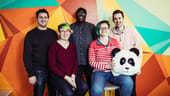 Wistia team members pose in front of a colorful wall with a panda bear head