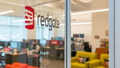 logo of redgate on glass door with view of office