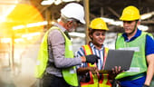 A construction crew looking at a laptop.