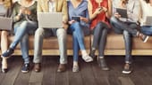 People consuming media on phones, tablets and laptops.