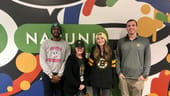 four employees standing in front of Nasuni mural