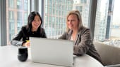 Yang Lu and Annette Hater work on a laptop together.