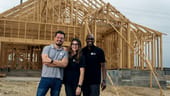 Members of the NewHomesMate executive team pose for a photo in front of an under-construction home.