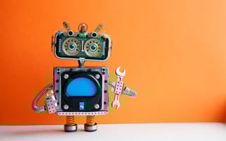 A robot holds a wrench in front of an orange background.