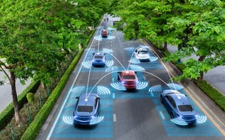 Cars drive down a tree-lined three-laned street with blue hologram overlays.