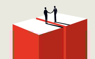 Two figures in business attire shake hands atop red and white boxes