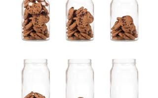 Six glass jars containing cookies but each jar progressively has less cookies until the sixth jar that is empty