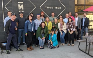adtaxi team members pose in front of black brick wall