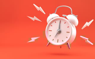 Image of a white alarm clock ringing against an orange background
