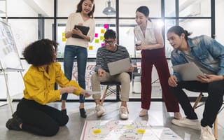 Image of five coworkers collaborating together in their office