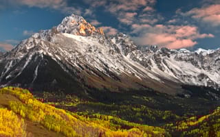 Image of Colorado's Rocky Mountains above green and yellow trees in autumn