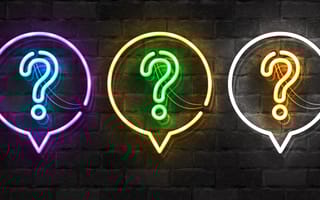 Image of brick wall with a row of three neon lights shaped like question marks within neon light speech bubbles