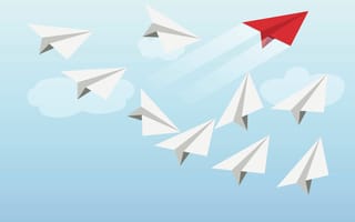 Paper airplanes soaring in formation. A red paper airplane soars ahead.