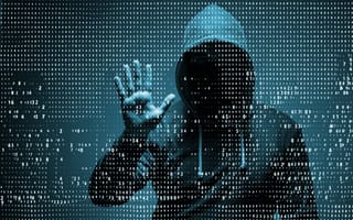 A mysterious man stares at a wall of data.
