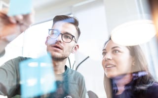 Bonusly employees work on a glass board