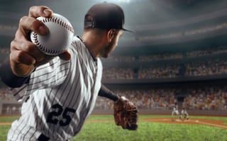 A baseball pitcher reeling back to throw. The camera is focused in on a baseball.