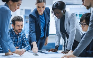 Business people gather around a table in a meeting