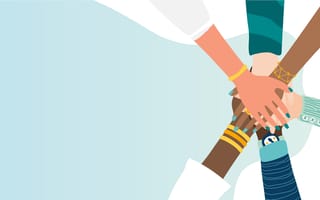 Different people join hands in a fit of teamwork.