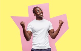 Man standing in front of abstract pink and yellow background, with fists upraised in excitement, ready to take on a new role