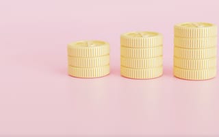 Three stacks of coins on a pink background