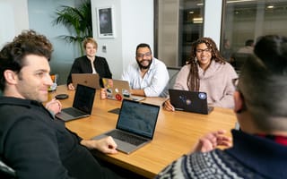 team meeting at desk with laptops