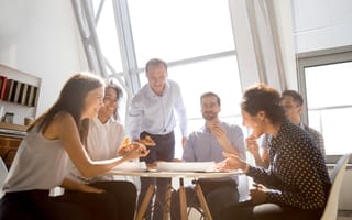 Employees laughing during a meeting.
