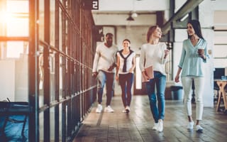 Image of two pairs of coworkers walking and talking in an office