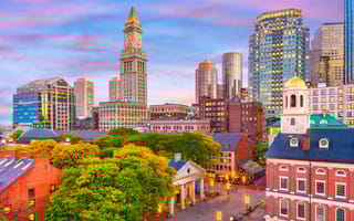 Boston skyline with Faneuil Hall and Quincy Market at dusk.
