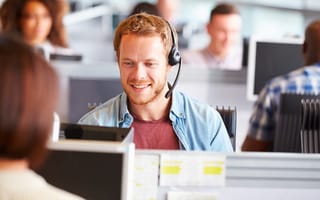Young man working at a computer in a call center