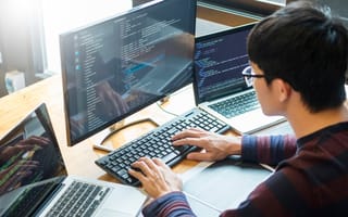 programmer working on a desktop computer programming code technologies