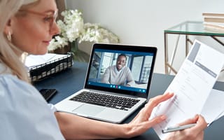 Woman looking a a resume while conducting an interview via video call